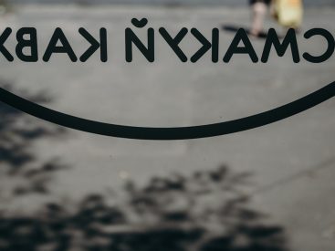 a close up of a sign with a person walking in the background