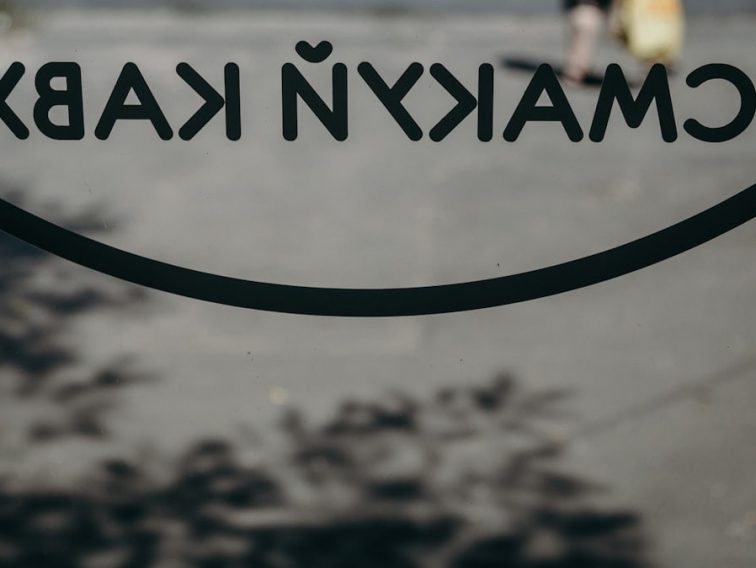 a close up of a sign with a person walking in the background